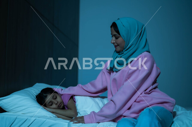 أم عربية خليجية سعودية تطمئن على ابنتها قبل النوم، طفلة تنام في سرير منعش ومريح على وسادة بيضاء ناعمة، مفهوم العناية والاهتمام بالأولاد، فوائد النوم المبكر، الاسترخاء والاستمتاع بالأجواء الهادئة، اتباع أسلوب حياة صحي