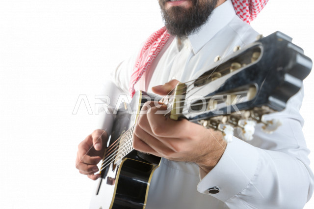 بورتريه شاب سعودي عربي خليجي يعزف على  الجيتار( آلة وترية) ، شاب باللباس السعودية التقليديه بخلفية بيضاء ، آلة موسيقية ، مجال صوتي و فني