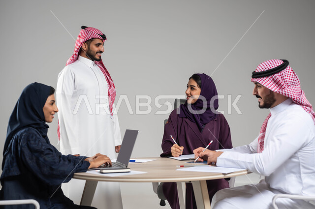 مناقشة خطط العمل, توفير بيئة عمل مريحة, مفهوم روح الفريق والإنجاز الجماعي, تطوير الاستراتيجيات و الأعمال, النجاح وتحقيق الاهداف, استخدام الاجهزة والتقنيات الحديثة في انجاز المهام المكتبية, بورتريه مقرب لموظفين عرب سعوديين خليجيين في اجتماع, خلفية رمادية
