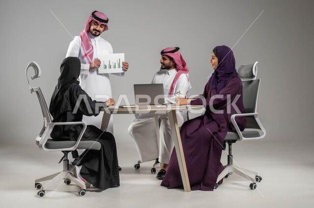 Explanation of charts and graphs, dialogues and discussions between colleagues, portrait of a Saudi Gulf Arab employee wearing a shemagh and traditional dress, holding papers in his hand, developing plans and strategies, using modern electronic technologies, gray background