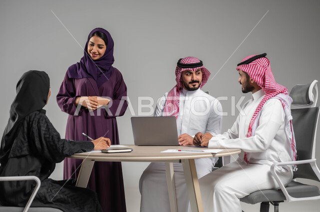 Study and discussion of new projects, providing a comfortable work environment, workshops and training, Saudi professions and jobs, a portrait of a Saudi-Gulf Arab work team cooperating to achieve the company’s strategies and goals, using modern techniques and technology, gray backgroun