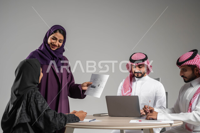 الشراكة والتعاون في الشركات السعودية, شرح المهام المطلوبة, ضمان فهم واضح للاعمال, مهن ووظائف سعودية, بورتريه لزملاء عمل عرب سعوديين خليجيين في اجتماع, ارتداء اللباس السعودي التقليدي, خلفية رمادية