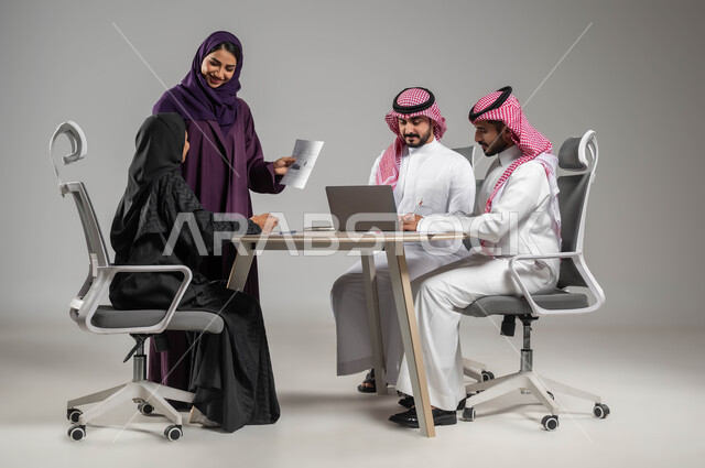 ضمان فهم واضح للاعمال, شرح المهام المطلوبة, مهن ووظائف سعودية, بورتريه لزملاء عمل عرب سعوديين خليجيين في اجتماع, ارتداء اللباس السعودي التقليدي, الشراكة والتعاون في الشركات السعودية, خلفية رمادية