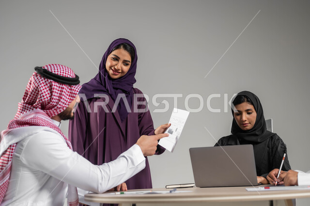 التركيز والعمل المتقن, اجتماع عمل وانجاز المشاريع, الحوارات والنقاشات ضمن الفريق, تطوير الاعمال والشركات, مناقشة الخطط وشرح مهام الاعمال, بورتريه لزملاء عمل عرب سعوديين خليجيين في اجتماع, ارتداء اللباس السعودي التقليدي, خلفية رمادية