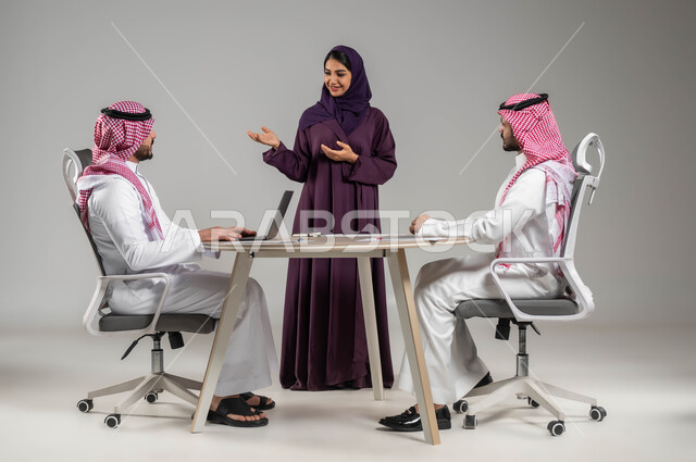 اجتماع عمل وانجاز المشاريع, الحوارات والنقاشات ضمن الفريق, تطوير الاعمال والشركات, مناقشة الخطط وشرح مهام الاعمال, بورتريه لزملاء عمل عرب سعوديين خليجيين في اجتماع, ارتداء اللباس السعودي التقليدي, خلفية رمادية