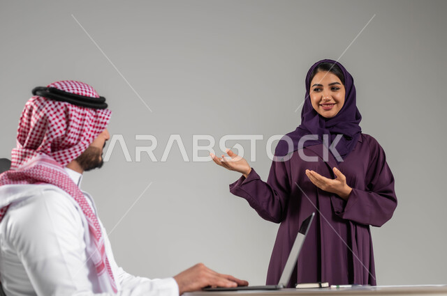 تطوير الاعمال والشركات, الحوارات والنقاشات ضمن الفريق, مناقشة الخطط وشرح مهام الاعمال, بورتريه لزملاء عمل عرب سعوديين خليجيين في اجتماع, ارتداء اللباس السعودي التقليدي, خلفية رمادية