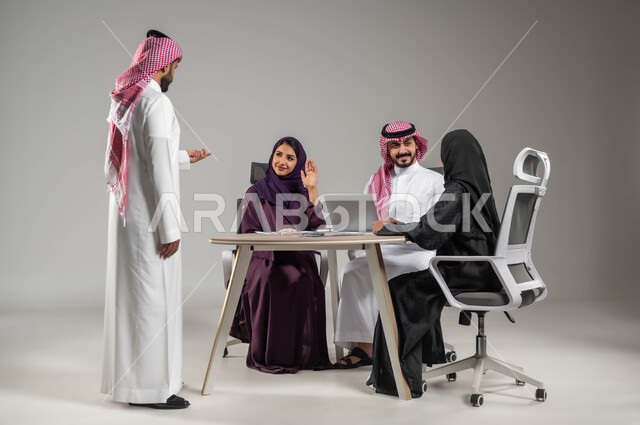 طلب الإذن لابداء الرأي، مناقشة الخطوات القادمة، الحوارات والنقاشات ضمن الفريق، ضمان فهم واضح للاعمال، التركيز والعمل الجاد، الاحترافية والتفاني في الإنجاز، استخدام اللابتوب للتدوين، بورتريه لموظفين عربيين خليجيين سعوديين في اجتماع، صورة لكامل الجسم، خلفية رمادية