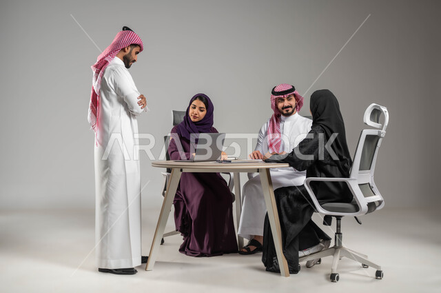 مناقشة الخطوات القادمة، شرح المهام المطلوبة، الحوارات والنقاشات ضمن الفريق، ضمان فهم واضح للاعمال، التركيز والعمل الجاد، الاحترافية والتفاني في الإنجاز، مهن ووظائف سعودية، استخدام اللابتوب للتدوين، بورتريه لموظفين عربيين خليجيين سعوديين في اجتماع، خلفية رمادية