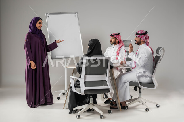 روح الفريق والعمل الجماعي، مناقشة خطط العمل، ضمان فهم واضح للاعمال، استخدام السبورة لتوضيح العمليات والاجراءات المتبعة في الشركة، استعمال اللابتوب في تدوين الملاحظات، التفاني في الإنجاز، بورتريه لفريق عربي خليجي سعودي في اجتماع، صورة لكامل الجسم، خلفية رماية