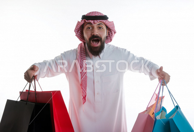بورتريه رجل سعودي خليجي يحمل حقائب تسوق  ، شراء الهدايا ،  الترفيه و التسوق ، خلفية بيضاء