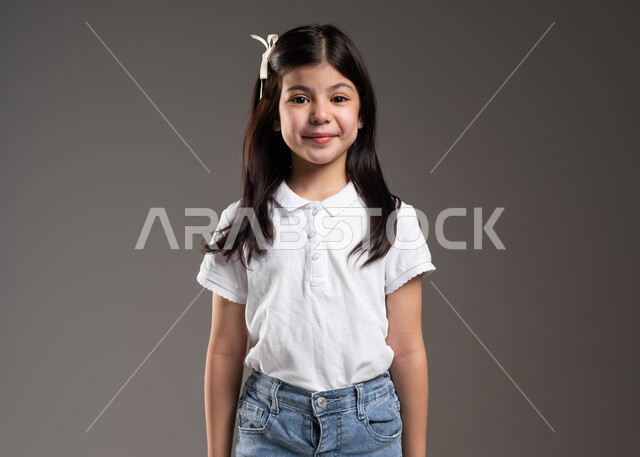 ايماءات وجه تدل على السعادة والسرور، صورة شخصية للوثائق الرسمية والمدرسية، بورتريه مقرب لفتاة عربية خليجي سعودية مبتسمة ترتدي الزي الكاجوال، الاستقامة والثبات أمام الكاميرا، خلفية رمادية