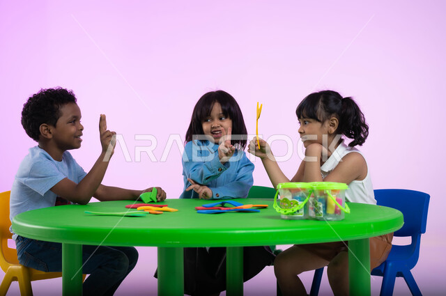 تعليم وإبداع وتنمية مهارات في رياض الأطفال، بورتريه لأطفال عرب خليجيين سعوديين يرتدون الزي الكاجوال يتعلمون الأرقام عن طريق اللعب والمرح، إيماءات تدل على الفرح والسعادة والسرور، دمج المتعة والفائدة في الروضة، خلفية وردية.