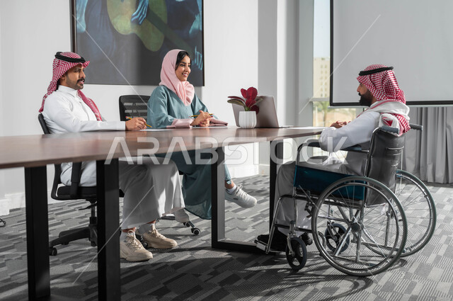 مفهوم المساواة بين النساء والرجال، مجموعة موظفين في غرفة الاجتماعات داخل مقر الشركة، اسلوب الحياة في الشركات السعودية، اتاحة المجال امام ذوي الهمم للدخول الى مجال العمل، استخدام الحاسب المحمول لتحقيق الأهداف وتطوير الخطط، التعاون والمحبة بين اعضاء الفريق الواحد