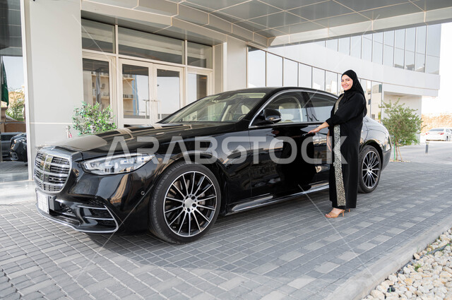 مفهوم الاستقلال والحرية والاعتماد على النفس، إمرأة عربية خليجية سعودية محجبة ترتدي العباءة تقوم بفتح باب سيارتها، حرية القيادة للسيدة العربية، اعتماد المرأه على نفسها في التنقل و المواصلات، الاستعداد لركوب السياره