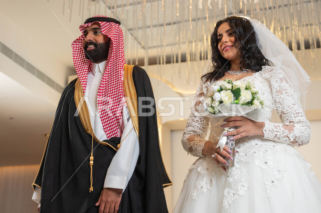أصالة العادات والتقاليد، مراسم الاعراس و المناسبات في المملكة، الفرح و السرور في يوم الزفاف، اجمل إطلالة لرجل عربي وسيم يرتدي الزي الرسمي والبشت التقليدي، صورة لعروسة عربية خليجية سعودية ترتدي فستان زفاف أبيض تمسك بيدها باقة ورد، مفهوم الاستقرار وتكوين عائلة