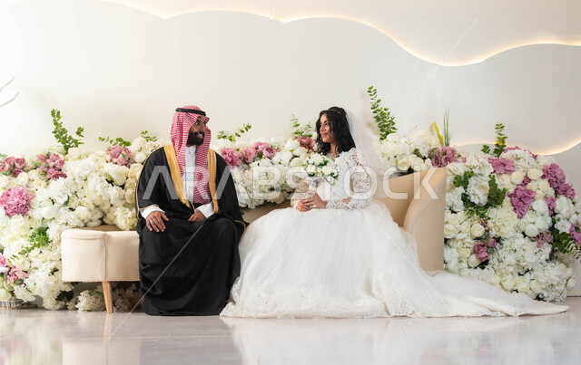 مفهوم الاستقرار و تكوين أسرة، الفرح و السرور في يوم الزفاف، اجمل إطلالة لرجل عربي وسيم يرتدي الزي الرسمي والبشت التقليدي، صورة لعروسة عربية خليجية سعودية ترتدي فستان زفاف أبيض تمسك بيدها باقة ورد، مراسم الاعراس و المناسبات في المملكة، أصالة العادات والتقاليد