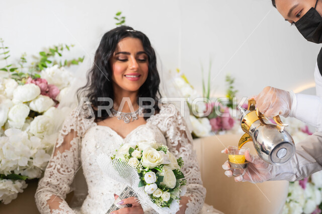 تقديم المشروبات الساخنة, الاحتفال في قاعة المناسبات والأفراح المزينة بالأزهار, صورة مقربة لمضيفة تقوم بصب القهوة السعودية الأصيلة، عروس عربية خليجية سعودية ترتدي فستان الزفاف الأبيض تمسك بيدها باقة الورد, مراسم الأعراس والزواج