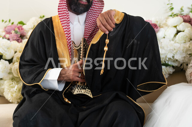التطيب بالبخور والعود ، أجمل اطلالة لشاب في يوم زفافه ، بورتريه لعريس عربي خليجي سعودي يرتدي الزي الرسمي والبشت التقليدي يحمل بيده المبخرة، مراسم الأعراس والاحتفالات في المملكة، قاعات مناسبات وأفراح مزينة، أصالة العادات والتقاليد، الفرح والسرور في يوم الزواج