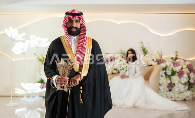 اجمل إطلالة لرجل عربي يرتدي الزي الرسمي والبشت التقليدي يحمل المبخرة، صورة لعروسة عربية خليجية سعودية ترتدي فستان زفاف أبيض تمسك بيدها باقة الورود، مراسم الاعراس و المناسبات في المملكة، الفرح و السرور في يوم الزفاف، مفهوم الاستقرار وتكوين عائلة