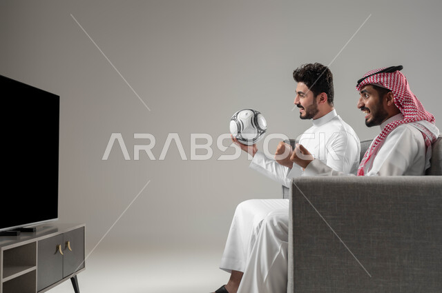 الاستعداد بحماس للانتصار, التفاعل والاندماج بمشاهدة الفريق المفضل, المباريات والالعاب الرياضية, بورتريه لرجلان عربيان سعوديان خليجيان احدهما يمسك بيده كرة القرم, قضاء اوقات ممتعة مع الاصدقاء, خلفية رمادية