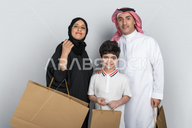 بورتريه لعائلة عربية سعودية خليجية سعيدة  تحمل حقائب التسوق ، شراء الهدايا ،  الترفيه و التسوق ، يوم التسوق ، الجمعة البيضاء