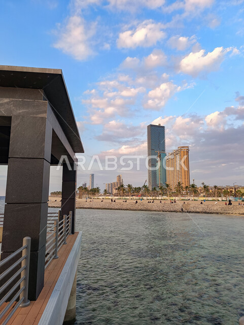 The famous tourist attractions of Jeddah, the waterfront of the Corniche of the city of Jeddah in the Kingdom of Saudi Arabia in broad daylight, enjoying contemplating the tranquility of the sea, the white clouds in the sky above the seashore, the architectural art of the towers and skyscrapers.