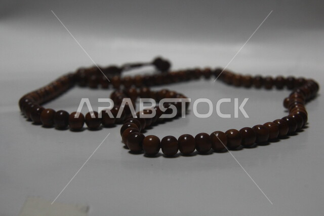 الاجتهاد في العبادة والتقرب إلى الله تعالى, صورة مقربة لسبحة مصنوعة من الخشب, قراءة الأذكار والتسبيحات اليومية, الأجواء الروحانية وأداء العبادات الدينية, الالتزام والتمسك بذكر الله