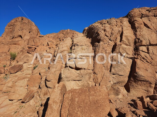 النحت الصخري والتضاريس في المناطق المرتفعة، التكوينات والتشكيلات الصخرية في المملكة العربية السعودية، الاستمتاع بالمناظر الطبيعية في وقت النهار، سلسلة الجبال المجاورة لصخرة سبليت في مدينة تبوك الصحراوية، معالم اثرية تاريخية قديمة سياحية مشهورة