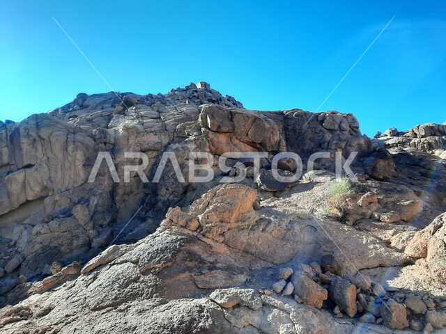 سلسلة الجبال المجاورة لصخرة سبليت في مدينة تبوك الصحراوية، التضاريس والنحت الصخري في المناطق المرتفعة، التكوينات والتشكيلات الصخرية في المملكة العربية السعودية، الاستمتاع بالمناظر الطبيعية في وقت النهار، معالم اثرية تاريخية قديمة سياحية مشهورة