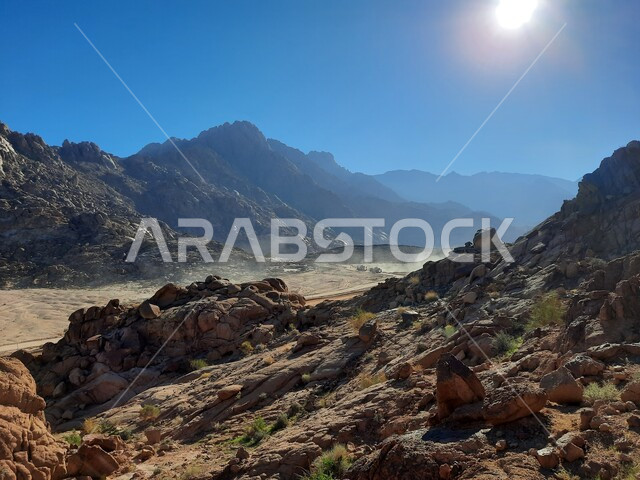 سلسلة الجبال المجاورة لصخرة سبليت في مدينة تبوك الصحراوية، التضاريس والنحت الصخري في المناطق المرتفعة، التكوينات والتشكيلات الصخرية في المملكة العربية السعودية، الاستمتاع بالمناظر الطبيعية في وقت النهار، معالم اثرية تاريخية قديمة سياحية مشهورة