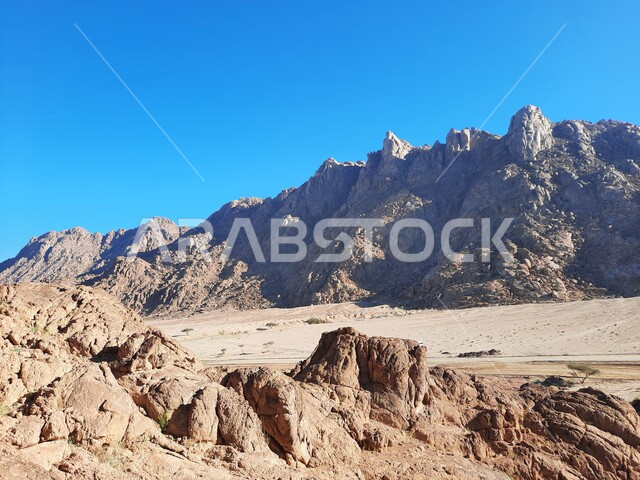 الاستمتاع بالمناظر الطبيعية في وقت النهار، سلسلة الجبال المجاورة لصخرة سبليت في مدينة تبوك الصحراوية، التضاريس والنحت الصخري في المناطق المرتفعة، التكوينات والتشكيلات الصخرية في المملكة العربية السعودية، معالم اثرية تاريخية قديمة سياحية مشهورة