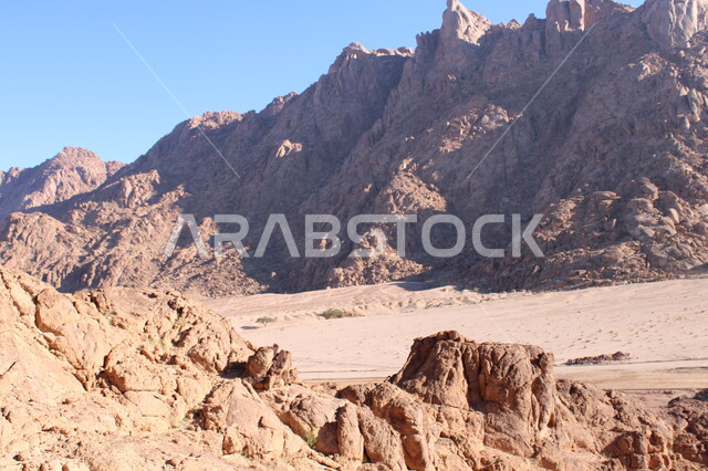 النحت الصخري والتضاريس في الجبال الرسوبية، التكوينات والتشكيلات الصخرية في المملكة، الاستمتاع بالمناظر الطبيعية في وقت النهار، سلسلة جبلية مجاورة لصخرة سبليت في مدينة تبوك الصحراوية، معالم اثرية تاريخية قديمة سياحية مشهورة