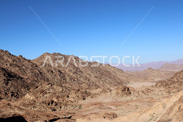 النحت الصخري والتضاريس في الجبال الرسوبية، التكوينات والتشكيلات الصخرية في المملكة، الاستمتاع بالمناظر الطبيعية في وقت النهار، سلسلة جبلية مجاورة لصخرة سبليت في مدينة تبوك الصحراوية، معالم اثرية تاريخية قديمة سياحية مشهورة