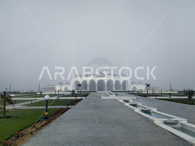 The outer courtyard of the Sharjah Grand Mosque in the United Arab Emirates, architectural art and designs in the Arab-Islamic style, famous religious landmarks in the Emirate of Sharjah, foggy skies and winter atmosphere, worship and getting closer to God, Islamic background