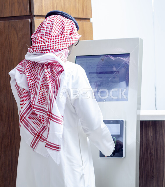 Technological development in the field of work in medical laboratories, development of biotechnology in scientific laboratories, a picture from the back of a Saudi Gulf Arab man wearing a traditional thobe and shemagh receiving the results of examining laboratory samples, providing services in medical centers in the Kingdom of Saudi Arabia
