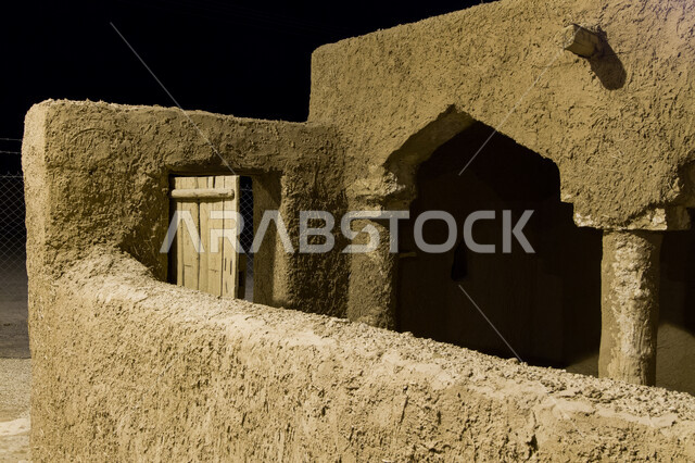 مسجد طيني عتيق على الطراز التاريخي الإسلامي القديم في وقت الليل، القرية التراثية في محافظة مرات التابعة لإمارة الرياض, معالم سياحية تراثية مشهورة, الحضارة والأصالة والعراقة السعودية, القرى القديمة لجذب السياح من شتى أنحاء العالم.