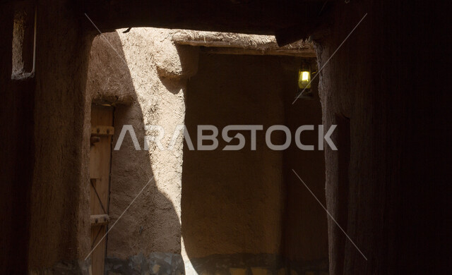The architectural engineering art of the alleys and ancient mud buildings in the village of Ushaiqar in Al-Shaqra Governorate, historical houses in the city of Riyadh, the ancient Arab architectural design of ancient antique wooden doors, famous heritage tourist places in Saudi Arabia.