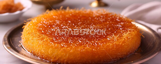 حلويات وسكريات بالقطر, قطع الحلوى الشهية على صحن معدني، وصفات شرقية مشهورة، صورة مقربة لطبق حلا الكنافة المحشوة بالقشطة، مطاعم ومأكولات في المملكة العربية السعودية