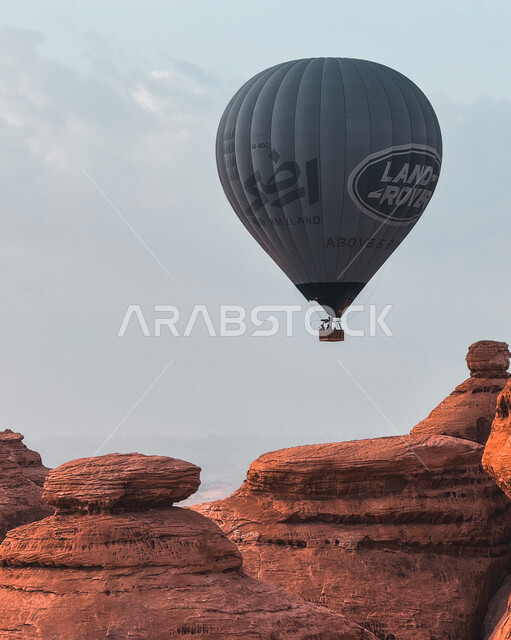 التشكيلات والتكوينات الصخرية في أماكن القمم والمرتفعات الجبلية, صورة مقربة لبالون الهواء الساخن فوق المعالم الأثرية القديمة التاريخية، المناطيد الطائرة في سماء السعودية، الأنشطة الترفيهية في محافظة العلا التراثية, وجهة عائلية سياحية طبيعية