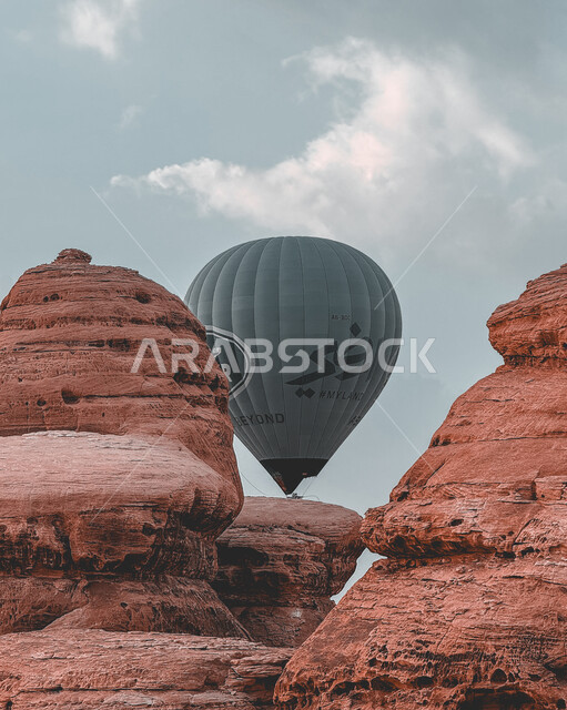 التشكيلات والتكوينات الصخرية في أماكن القمم والمرتفعات الجبلية, صورة مقربة لبالون الهواء الساخن فوق المعالم الأثرية القديمة التاريخية، المناطيد الطائرة في سماء السعودية، الأنشطة الترفيهية في محافظة العلا التراثية, وجهة عائلية سياحية طبيعية