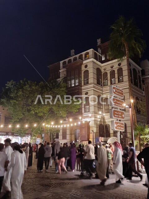 Crowds of people in the illuminated streets of Jeddah at night, ancient-style architectural buildings, places that attract and attract tourists from all over the world, famous historical and political landmarks in Saudi Arabia, the old historic Beit Nassif Palace, an important center for holding meetings in Hejaz.