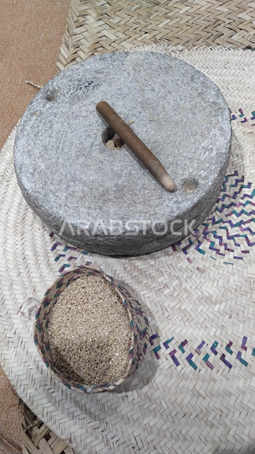 أدوات والات تراثية شعبية تقليدية, صورة مقربة من الأعلى لمطحنة حبوب حجريه يدويه, استخدام آلة الرحى للطحن في المملكة العربية السعودية, معدات خليجية أثرية
