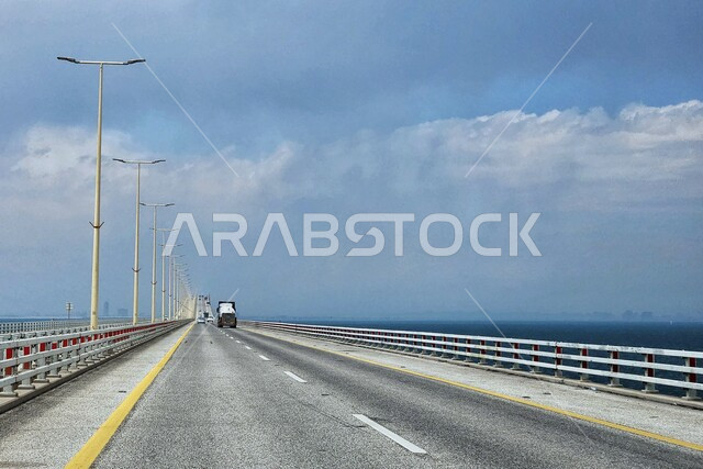 طريق اسفلتي سريع مخصص للسفر بين المدن، جسر معلق ومدعم بالكوابل، التصميم الهندسي المعماري للطرق والشوارع، منظر السحب البيضاء في سماء السعوديه