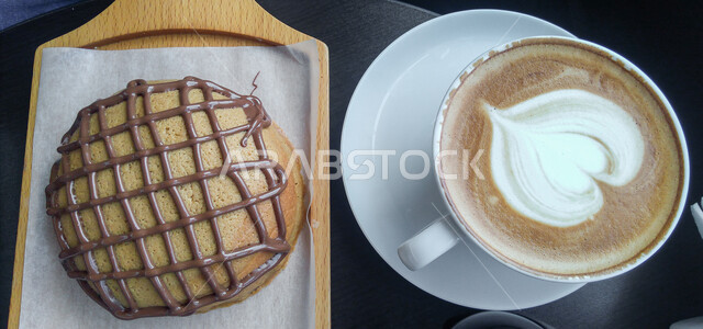 كوب القهوة الساخن، خبز البنز المزين بالشوكولاته، حلا إيطالي لذيذ، حلويات غربية هشة ومقرمشة، مأكولات غنية بالسكريات والسعرات الحرارية