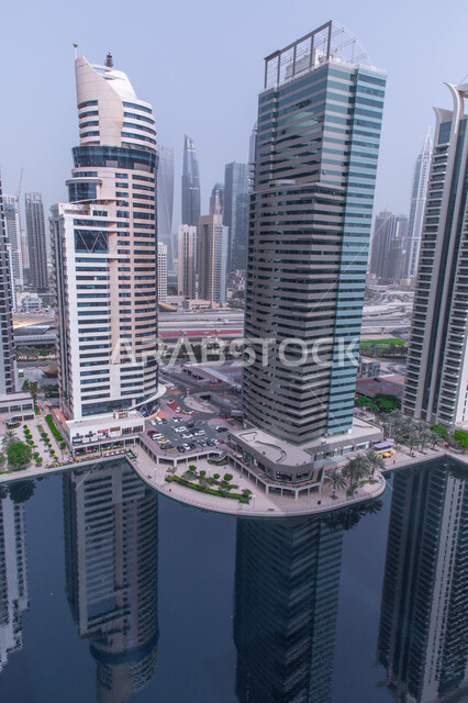 Urban engineering and technical development in the United Arab Emirates, towers and skyscrapers overlooking the ship dock in Dubai Marina, the reflection of commercial facilities on the artificial sea, famous Dubai landmarks in daylight, the waterfront on the Arabian Gulf coast