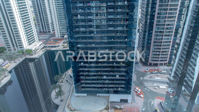 Architectural engineering in a modern and advanced style for constructing buildings and skyscrapers in the city of Dubai, towers overlooking the yacht marina in Dubai Marina on the coast of the Arabian Gulf, famous tourist attractions in daylight, commercial establishments in the city of the United Arab Emirates