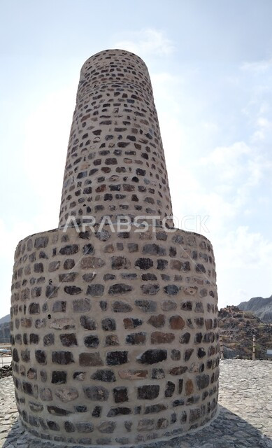 المعالم التاريخيه القديمة ,الأماكن السياحية التراثية, الفن الهندسي المعماري على الطراز الفريد المميز, برج العدواني الأثري المبني من الحجارة في مدينة خورفكان في إمارة الشارقة فى الامارات العربية المتحدة, خلفية السماء الزرقاء