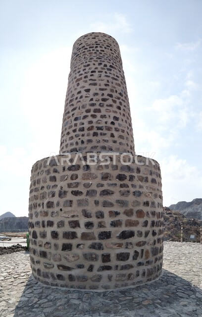 الأماكن السياحية التراثية, الفن الهندسي المعماري على الطراز الفريد المميز, برج العدواني الأثري المبني من الحجارة في مدينة خورفكان في إمارة الشارقة فى الامارات العربية المتحدة, المعالم التاريخيه القديمة ,خلفية السماء الزرقاء