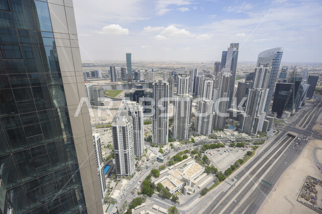 المنشآت التجارية في الإمارات العربية المتحدة، الهندسة الفنية المعمارية على الطراز الحديث والمتطور لبناء المباني وناطحات السحاب في دبي, صورة جوية للأبراج في وسط المدينة في وضح النهار, الاهتمام بزراعة الأشجار الخضراء في المدن