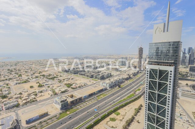 الهندسة الفنية المعمارية على الطراز الحديث والمتطور لبناء المباني وناطحات السحاب في دبي, صورة جوية للأبراج في وسط المدينة في وضح النهار, المنشآت التجارية في الإمارات العربية المتحدة، الاهتمام بزراعة الأشجار الخضراء في المدن